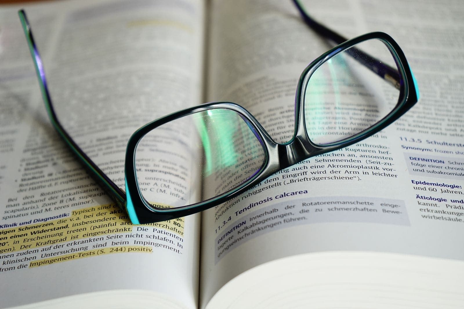 A pair of glasses resting on an open book